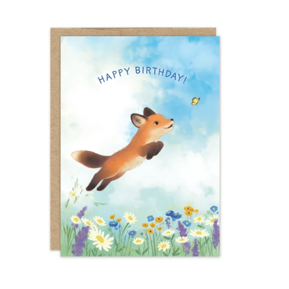 A joyful fox leaps toward a butterfly on this charming Little Fox Birthday Card by Biely & Shoaf.
