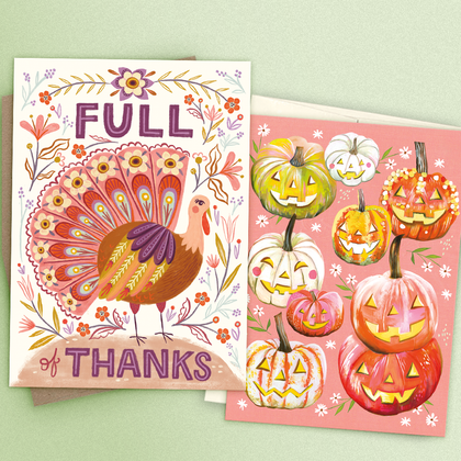 An orange Halloween greeting card with a decrepit haunted house and harvest moon on a kraft elope and orange background.