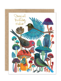 The Birds & Mushrooms - Luxe Birthday Card by Biely & Shoaf features four vibrant birds among mushrooms with "Magical Birthday Wishes" in gold. Includes an eco-friendly brown envelope.