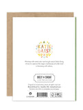 The back of the Violet Petals Luxe Birthday Card displays "Katie Daisy" in colorful floral letters at the top, a brief artist bio, and Biely & Shoaf branding with copyright and eco-friendly logos at the bottom.