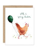 The Biely & Shoaf Spring Chicken Luxe Birthday Card features a cheerful chicken with a green balloon and "still a spring chicken" above. This eco-friendly square card comes with a brown envelope, adding charm to any occasion.