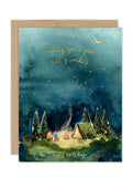 The Biely & Shoaf Starry Night - Luxe Birthday Card features three people by a campfire near a tent under a starry sky, with gold text: Wishing you a year full of wonders and Happy Birthday. Part of the eco-friendly A2 Luxe Collection.