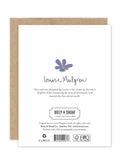 The back of this Rainbow Flowers Luxe Birthday Card by Biely & Shoaf displays a small blue flower, brand name, eco-friendly design text, and includes logos, a barcode, and FSC recycling symbols at the bottom.