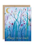 The Moonlit Branches Luxe Sympathy Card by Biely & Shoaf features watercolor tree branches, colorful budding flowers, a crescent moon, and “Always in our hearts” in gold script on a blue background.