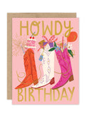 The Biely & Shoaf Howdy Luxe Birthday Card features three colorful cowboy boots with a cake, candles, flowers, and balloons on a pink background, accented by bold gold "HOWDY BIRTHDAY" lettering. Eco-friendly from the A2 Luxe Collection.