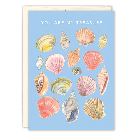 The Biely & Shoaf Seashells I Treasure You Love Card features a light blue recycled paper background with illustrated seashells and the message "YOU ARE MY TREASURE" in white, paired with a cream-colored envelope.