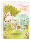 The Biely & Shoaf Greenhouse Garden Party Birthday Card features a charming garden scene with flowers, a tree, greenhouse, and table for two. Happy birthday appears in the sky—perfect as an eco-friendly recycled paper card.