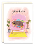 The Biely & Shoaf Cozy Dog Get Well Card features a brown dog resting on a pink couch with colorful pillows, two potted plants, and get well soon above in elegant script. Illustrated by Emma Block.
