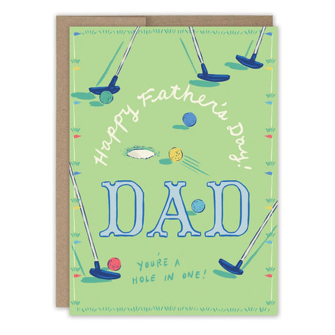 The Golf Father's Day Card by Biely & Shoaf features golf putters, balls, and "Happy Father's Day! DAD You're a hole in one!" on a green background. Illustrated by Emily Taylor and printed in the USA.