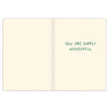 The Biely & Shoaf Paper Wrapped Bouquet Mother’s Day Card features an open, illustrated design with a plain cream interior. "YOU ARE SIMPLY WONDERFUL" appears in green on the right; the left side is blank. Designed by Emily Taylor.