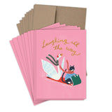 The Laughing All The Way Boxed Holiday Cards by Biely & Shoaf feature a pink design with a goose and black cat in scarves sledding, "Laughing all the way" in gold foil, and come with matching cards and brown recycled paper envelopes.
