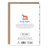 The back of a Pink Motif Merry Christmas Boxed Holiday Card by Biely & Shoaf features festive design details, artist info, and branding. The card on a brown envelope highlights eco-friendly FSC-certified materials. Set includes 10 cards.