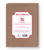 A brown box labeled Biely & Shoaf contains 10 Festive Cocktails Boxed Holiday Cards and envelopes. The label features a festive design with gold foil accents and a holiday greeting, standing upright against a white background.