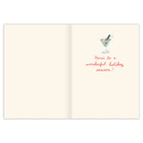 The Festive Cocktails Boxed Holiday Card by Biely & Shoaf is printed on recycled paper, featuring a cocktail with green garnish and red handwritten "Here's to a wonderful holiday season!" message; left page is blank.