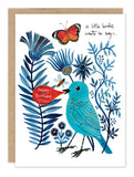The A Little Birdie Birthday Card by Biely & Shoaf features Geninne Zlatkis’s illustration of a blue bird with blue flowers, a red "Happy Birthday" bubble, and a butterfly. Printed on FSC-certified recycled paper.