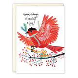 The Biely & Shoaf Red Bird Good Tidings Holiday Card features a red bird with a beret holding a green twig, perched on a branch with berries and a yellow gift, gold foil accents, and Good tidings of comfort & joy! in handwritten script.