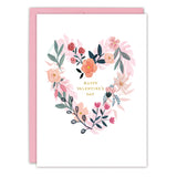 The Floral Heart Valentine's Day Card by Biely & Shoaf features a watercolor flower heart, gold "HAPPY VALENTINES DAY" text, a pink envelope, and is printed on FSC-certified recycled paper for an eco-friendly touch.