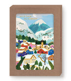 The All Is Calm Snowy Village Boxed Holiday Cards by Biely & Shoaf feature a colorful winter village with snow-covered houses, mountains, and gold-foil “ALL IS CALM, ALL IS BRIGHT”; framed in a brown box—ideal for holiday greetings.
