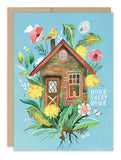 Send cozy wishes with the Biely & Shoaf Home Sweet Home Card, featuring a charming house, flowers, bird, butterflies, and “Home Sweet Home” text on a blue background—perfect for celebrating life’s good moments.