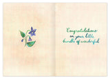 The Garden Welcome Sweet Baby Card by Biely & Shoaf features a purple flower with green leaves, “Congratulations on your little bundle of wonderful” in cursive, and is printed on FSC-certified recycled paper.