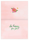 The Biely & Shoaf Country Blooms Congrats Card features an open greeting card with a pink polka dot background, floral and butterfly accents with gold foil, and green text saying "So happy for you!" in Katie Daisy's charming style.