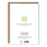 The back of the Very Best Mom Floral Mother's Day Card by Biely & Shoaf displays a floral wreath, a short artist bio, and publishing info. A brown envelope is partially shown behind the card. Printed in the USA.