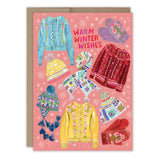 The Cozy Sweaters Warm Wishes Holiday Card by Biely & Shoaf features “Warm Winter Wishes” in gold foil, with colorful sweaters, hats, scarves, and mittens on a pink snowflake background. Printed on FSC-certified paper.