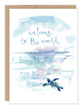 The Biely & Shoaf Turtle Welcome To The World Baby Card features a watercolor-style sea turtle on a beach with ocean waves and the handwritten message “welcome to the world.” It includes a plain brown envelope.