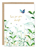 The Biely & Shoaf "Here For You Sympathy Card" features watercolor-style green leaves, blue flowers, a blue butterfly, and gold text reading "here for you always." Brown envelope and recycled paper card are partially visible behind.