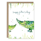 The Biely & Shoaf Snappy Father's Day Card features a Louise Mulgrew illustration of two green crocodiles among leafy plants with "Snappy fathers day" text. The crocodiles face each other and the card includes a brown envelope.