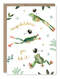 Frogs Graduation Card by Biely & Shoaf features three colorful frogs leaping among caps, stars, and leaves with “congratulations you did it!” in handwritten text. Printed on recycled paper, this cheerful card is perfect for celebrating any grad.