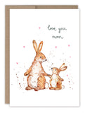 The Biely & Shoaf Bunnies Mother's Day Card features two brown rabbits, one large and one small, surrounded by pink hearts with "love you mom" handwritten above. This charming card comes with a brown envelope.