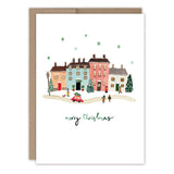 The Little Christmas Village Holiday Card by Biely & Shoaf features colorful houses, people, a red car, trees, and falling snowflakes with Merry Christmas below. Printed on recycled paper for an eco-friendly holiday greeting.