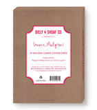 A red box labeled Biely & Shoaf presents Red Sky Cozy Christmas Boxed Holiday Cards, made with recycled paper. A message reads, Happy holidays from our home to yours. Box includes a barcode and product details.