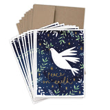 Biely & Shoaf’s Dove Peace On Earth Boxed Holiday Cards feature a white dove with an olive branch on a starry blue background, “Peace on Earth” in gold foil, brown envelopes, and are printed on recycled paper.