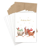 Three chickens in scarves on "Chickens Christmas Cheer" holiday cards by Biely & Shoaf, set on recycled paper.