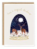 Two reindeer in snow under a full moon. Biely & Shoaf card reads: Have a magical Christmas.