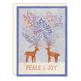 Two illustrated deer with antlers adorned in colorful leaves and flowers stand on snowy ground beneath falling snowflakes. PEACE & JOY in gold foil accents the front. Biely & Shoaf’s Peace & Joy Reindeer Boxed Holiday Cards (set of 10), made with FSC-certified paper.