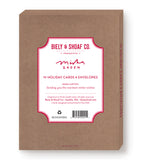 A brown box of 10 “Peace Love Color Joy” holiday cards and envelopes by Biely & Shoaf, featuring Misha Zadeh’s gold foil design. The box includes red and white labeling, product details, and a barcode on the lower right corner.