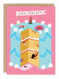 The Dive Into Cake Birthday Card by Biely & Shoaf features Sarah Long’s illustration of a three-layer cake with blue icing and white dollops, set on pink, where people swim and lounge as if it's a pool—complete with a “Happy Birthday” banner.